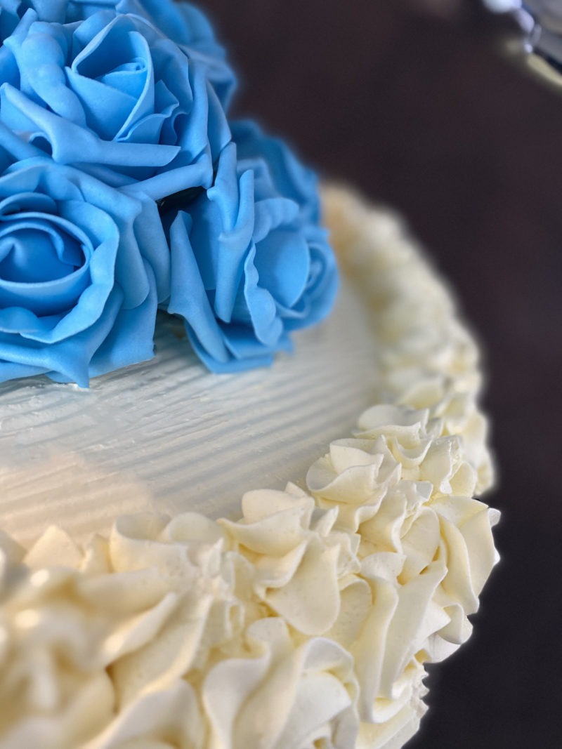 wed 4 scaled <div class="woocommerce-product-details__short-description" style="text-align: center;">3 Tier wedding cake on a stand with blue flowers</div>